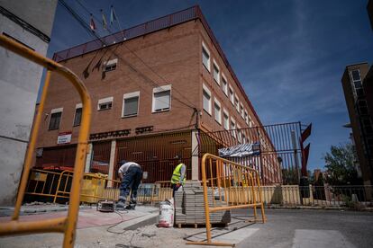 Dos operarios trabajan al sol frente al colegio público Francisco de Goya en el barrio de Puerta del Ángel (Madrid) el día 24. 
