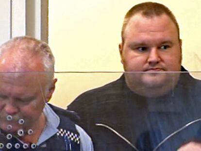Kim Dotcom, el fundador de Megaupload, ayer, custodiado por un agente de policía durante su detención en Nueva Zelanda.