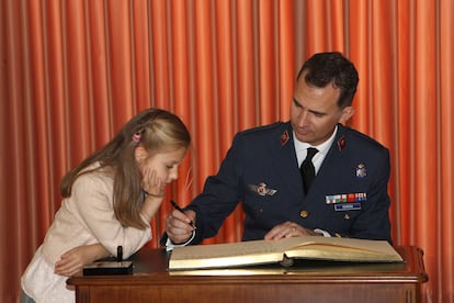 Leonor de Borbón mira como su padre don Felipe firma un libro durante la entrega de despachos de Teniente a la XLI promoción de la Academia General del Aire en Murcia, el 2 de mayo de 2014.
