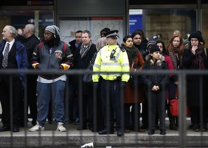 A police officer helps commuters to board buses during London Underground strikes at Kings Cross underground station in London February 6, 2014. Millions of commuters faced a second day of travel chaos on Thursday due to a 48-hour strike by London Underground workers angry over ticket office closures and job cuts, with no sign of an end to the standoff between unions and rail bosses.  REUTERS/Olivia Harris (BRITAIN - Tags: BUSINESS EMPLOYMENT TRANSPORT CIVIL UNREST)