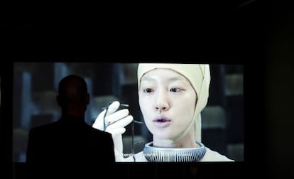 Un hombre mira la película 'News from Nowhere. El fin del mundo 2012' de los artistas coreanos Moon Kyungwon y Jeon Joonho en documenta.