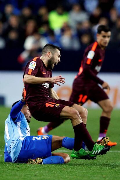 El defensa del FC Barcelona, Jordi Alba (d), cae ante la entrada del centrocampista del Malaga, Samuel García, y que ha significado la expulsión del jugador malacitano.