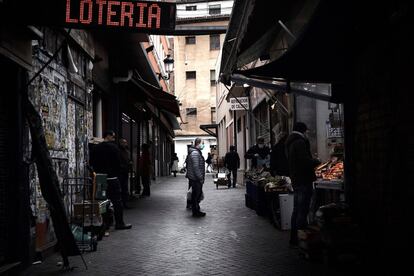 Un hombre espera su turno en una frutería del mercado de Antón Martín en Madrid.