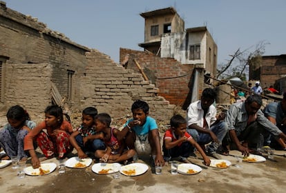 Un grupo de niños, afectados por la tormenta que ha azotado al sureste de Nepal, comen sentados sobre el suelo en su aldea, en el distrito de Bara. Al menos 30 personas han muerto y cerca de 500 han resultado heridas.