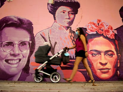 Una mujer camina junto al mural restaurado de las mujeres del barrio de Ciudad Lineal en Madrid, este sábado.