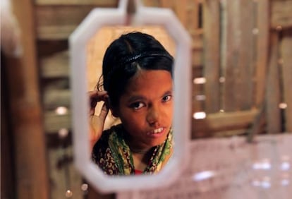 Nilima, una niña de Bangladesh de 14 años, reflejada en el espejo de su casa.