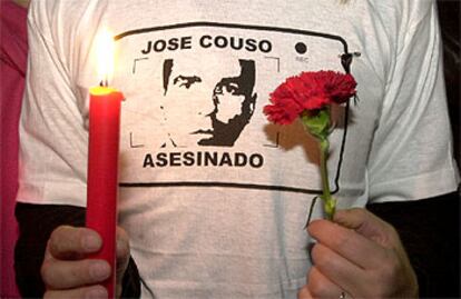 Un compañero del cámara español sostiene un clavel y una vela durante un homenaje en la Plaza de Olavide de Madrid.