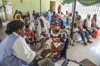 La neumonía se cobra la vida de más de 800.000 niños menores de cinco años cada año en todo el mundo. En Nigeria es donde más niños mata: 162.000 en 2018, según Unicef. Casi todas estas muertes se pueden prevenir con una vacuna y tratamiento. En la imagen, una sanitaria prepara una vacuna antineumocócica conjugada (PCV, en sus siglas en inglés) para un bebé, sentado en el regazo de su madre, mientras otras esperan la inmunización de sus hijos en una clínica de salud en Yola, en el estado de Adamawa, al noreste de Nigeria.