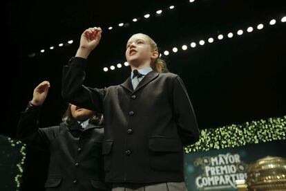 Las niñas de San Ildefonso Lorena Stefan (d) y Nicole Valenzuela (i), han cantado uno de los quintos premios que ha recaído en el número 46.984, agraciado con 6.000 euros al décimo, en el sorteo extraordinario de la Lotería de Navidad