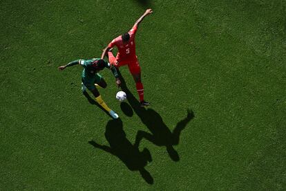 El centrocampista Martin Hongla (de rojo) pugna por el balón con el defensa camerunés Manuel Akanji. 