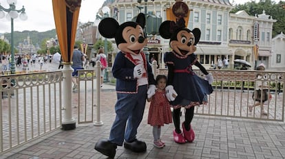 Una niña posa con los figurantes en el parque de Euro Disney en París.