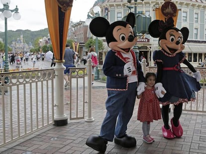 Una ni&ntilde;a posa con los figurantes en el parque de Euro Disney en Par&iacute;s.