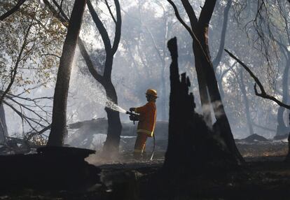 Un bombero intenta apagar un incendio forestal declarado en Taylors Lane en Wallan (Australia) el 9 de enero de 2013.