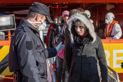 Un agente de la policía nacional ayuda a una inmigrante embarazada a desembarcar del buque de salvamento marítimo Clara Campoamor, en el que han llegado hoy al muelle de La Curra en el puerto de Cartagena 48 inmigrantes argelinos rescatados ayer en aguas de Cartagena.