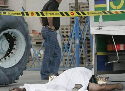 El cuerpo del trabajador fallecido, ayer, junto a la rueda reventada que le provocó la muerte.