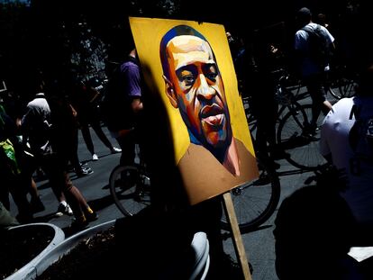 Un manifestante sostiene una imagen con el rostro de George Floyd, el afroamericano asesinado por un policía blanco en Nueva York.