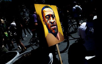 Un manifestante sostiene una imagen con el rostro de George Floyd, el afroamericano asesinado por un policía blanco en Nueva York.