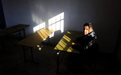Un niño palestino permanece sentado en una de las aulas de una escuela prefabricada en la localidad de Khirbet Tana, cerca de la ciudad cisjordana de Nablus.