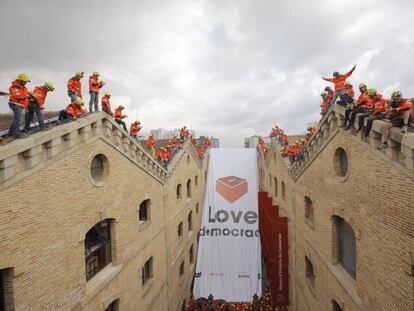 Membres de la sectorial Bombers per la Independència pengen una pancarta amb el lema 'Love democracy'.