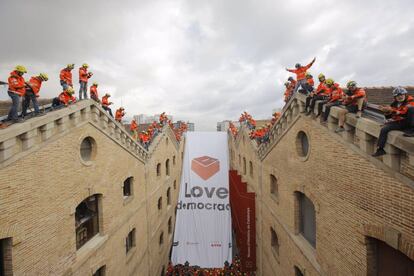 Membres de la sectorial Bombers per la Independència pengen una pancarta amb el lema 'Love democracy'.
