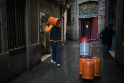 Un repartidor de bombonas de butano hace el reparto por las calles de la ciudad de Barcelona.  