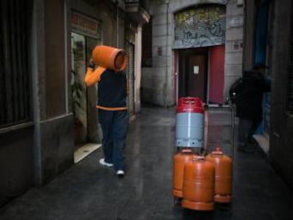 Un repartidor de bombonas de butano hace el reparto por las calles de la ciudad de Barcelona.  