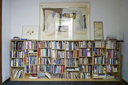 Sobre una de les nombroses llibreries de la casa, un quadre de gran format d'Antoni Llena.