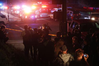 Un grupo de personas y varios periodistas esperan junto al cordón policial tras el tiroteo en el bar Borderline, en Thousand Oaks, a las afueras de Los Ángeles.