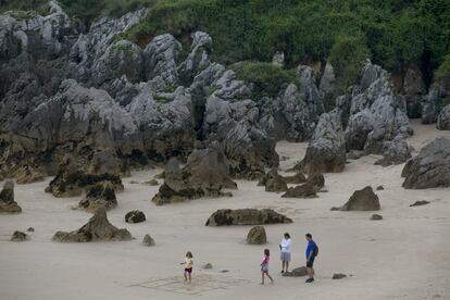 La Playa de Toró en Llanes en bajamar deja un paisaje de rocas saliendo de la arena.