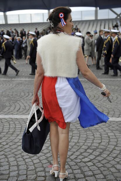 Una mujer, que viste con los colores la bandera francesa, accede a la zona de autoridades en la parada militar del 14 de julio.