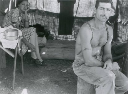 Un leñador parado acude con su mujer a la recogida de judías.. Lleva en su brazo tatuado el número de seguridad social. Oregón, 1939