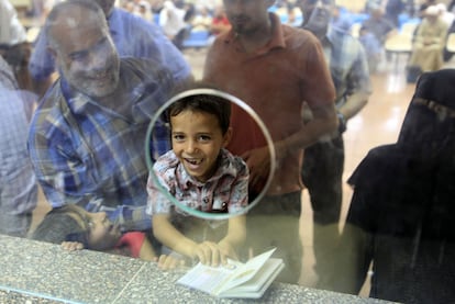 Un niño palestino muestra el pasaporte de su padre en el lado egipcio de la frontera.