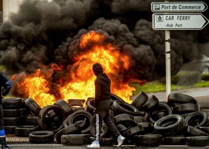 Un pescador de Boulogne (Francia) en la entrada bloqueada por neumáticos en llamas del puerto Boulogne-sur-Mer durante unas protestas.