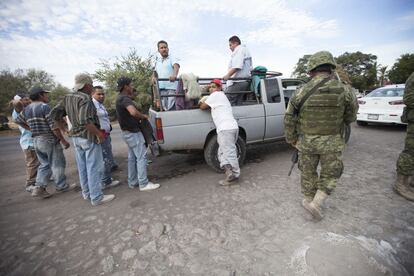 Miembros del Ejército Mexicano inspeccionan vehículos en la carretera que une Apatzingán con el poblado de Aguililla, Michoacán.