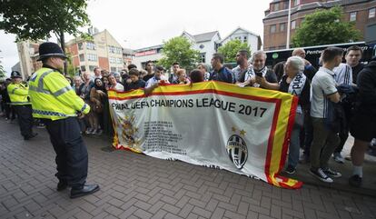 Agentes de policía permanecen en guardia ante la llegada de los jugadores del Real Madrid al hotel de concentración del equipo, en la víspera de la final de la Liga de Campeones entre el Real Madrid y el Juventus.