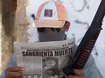 Un hombre del municipio de Ayutla en Guerrero, México, que combate al crimen organizado lee los sucesos en el periódico en una foto de archivo.