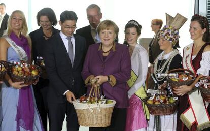 Angela Merkel y otros miembros de su Gobierno reciben manzanas en la Canciller&iacute;a durante una celebraci&oacute;n tradicional.