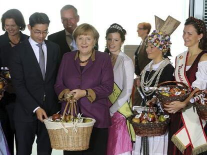 Angela Merkel y otros miembros de su Gobierno reciben manzanas en la Canciller&iacute;a durante una celebraci&oacute;n tradicional.