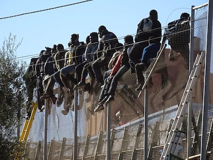 Un grupo de inmigrantes subsaharianos se queda atrapado en la valla fronteriza de Melilla tras intentar superarla en 2014.