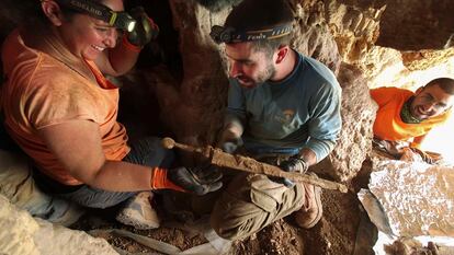 Dos arqueólogos extraen una de las cuatro espadas romanas halladas en Israel.