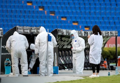 Sanitarios desinfectan las gradas durante el partido Pumas-Tigres correspondiente a la jornada 6 del Torneo Guardianes 2020 del fútbol mexicano, en el estadio Universitario de la ciudad de Monterrey (México).