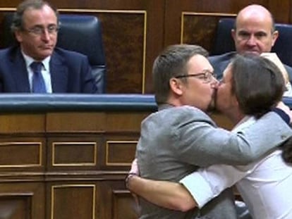 El líder de Podemos, Pablo Iglesias, y el de En Comú Podem, Xavier Domènech, se besan en el Congreso durante la segunda jornada del debate de investidura del líder socialista.