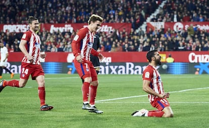 Diego Costa celebra su gol ante el Sevilla mientras Griezmann y Gabi acuden a felcitarle