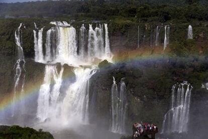 Un arco iris surge por encima de unos turistas de visita en las cataratas de Iguazú, en Brasil. Las cascadas, en la frontera entre este país y Argentina, forman parte del acuífero guaraní, una de las mayores reservas de agua subterránea del mundo. Marzo de 2015.