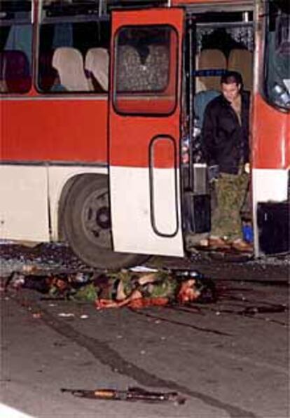 Un policía de élite ruso observa el cadáver del secuestrador del autobús.