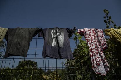 Los refugiados cuelgan su ropa en una alambrada.