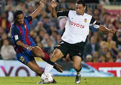 Ronaldinho (izqda.) lucha por el balón con el valencianista Oliveria, autor del único tanto del partido.