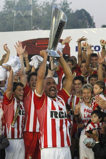 Verón alza el trofeo de campeón con sus compañeros en segundo término.