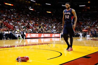 Mike Scott, de los Atlanta Hawks, recoge su zapatilla durante el partido ante Miami