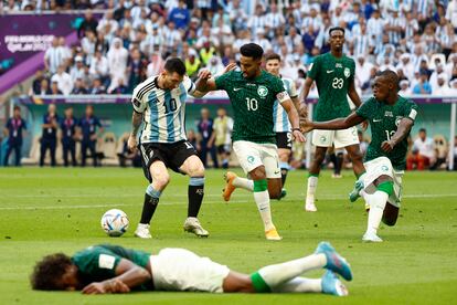  Lionel Messi (i) de Argentina disputa el balón con Salem Aldawsari de Arabia Saudita (c) frente al jugador lesionado Yasser Alshahrani (abajo) hoy, en un partido de la fase de grupos del Mundial de Fútbol Qatar 2022 entre Argentina y Arabia Saudita en el estadio de Lusail  (Catar).